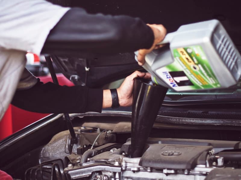 Vidange en cours : huile moteur neuve versée dans le carter d’un moteur essence